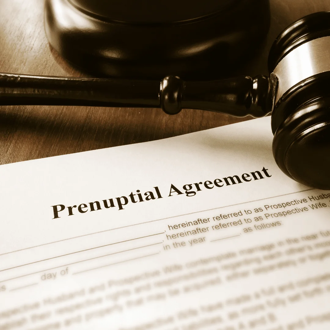 A picture of a judge gavel sitting on top of a prenuptial agreement.